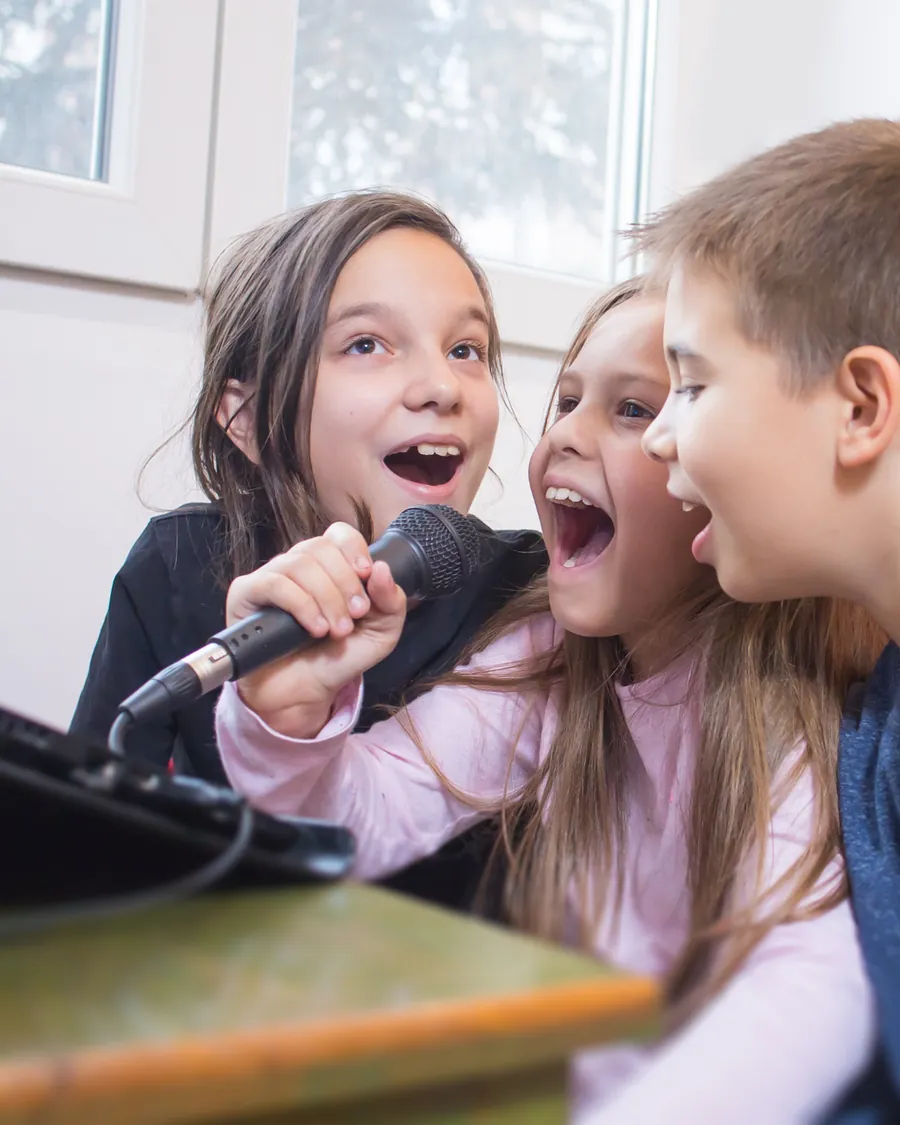 Crianças cantando juntas em aula de canto na Louvarte