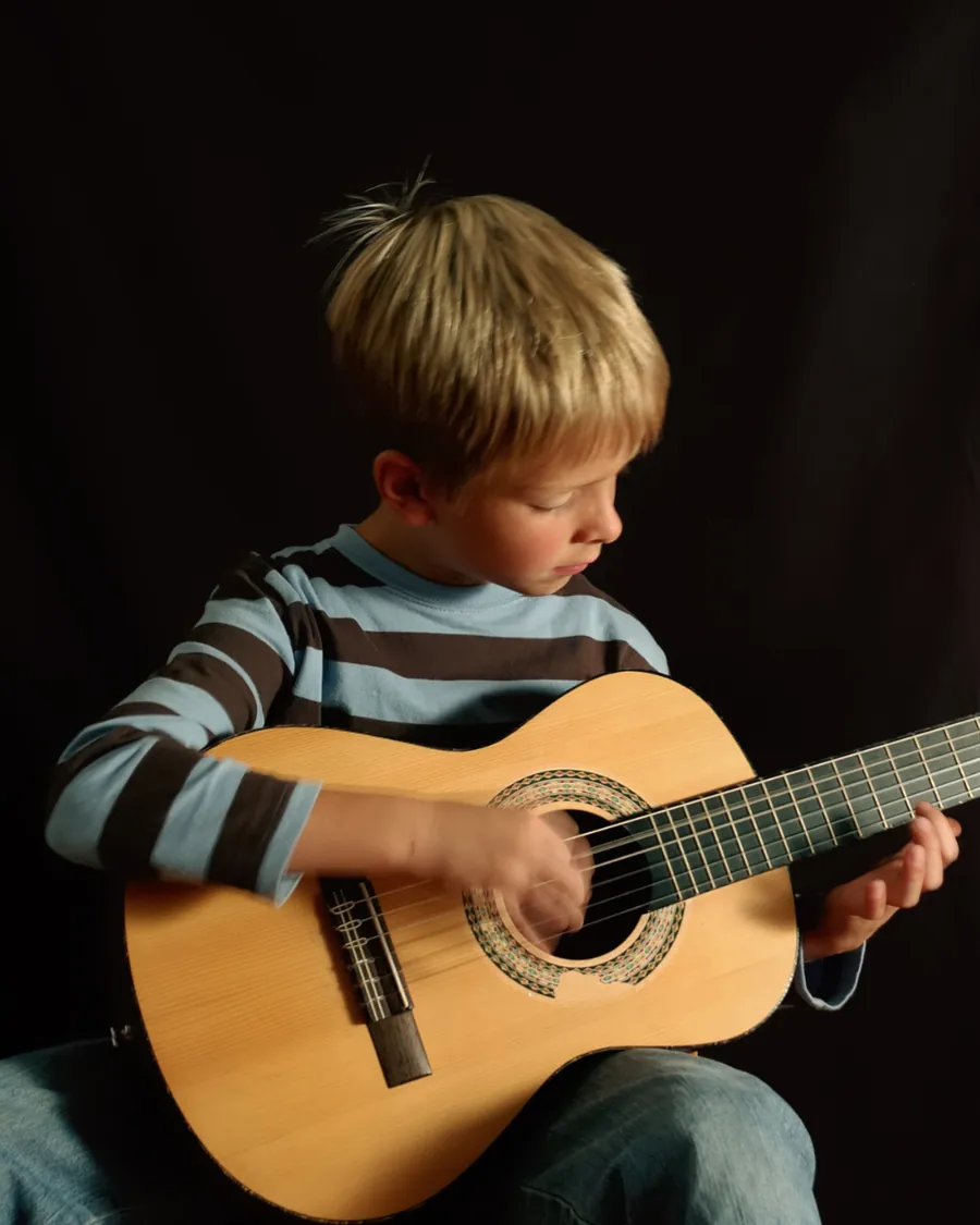 Criança aprendendo violão